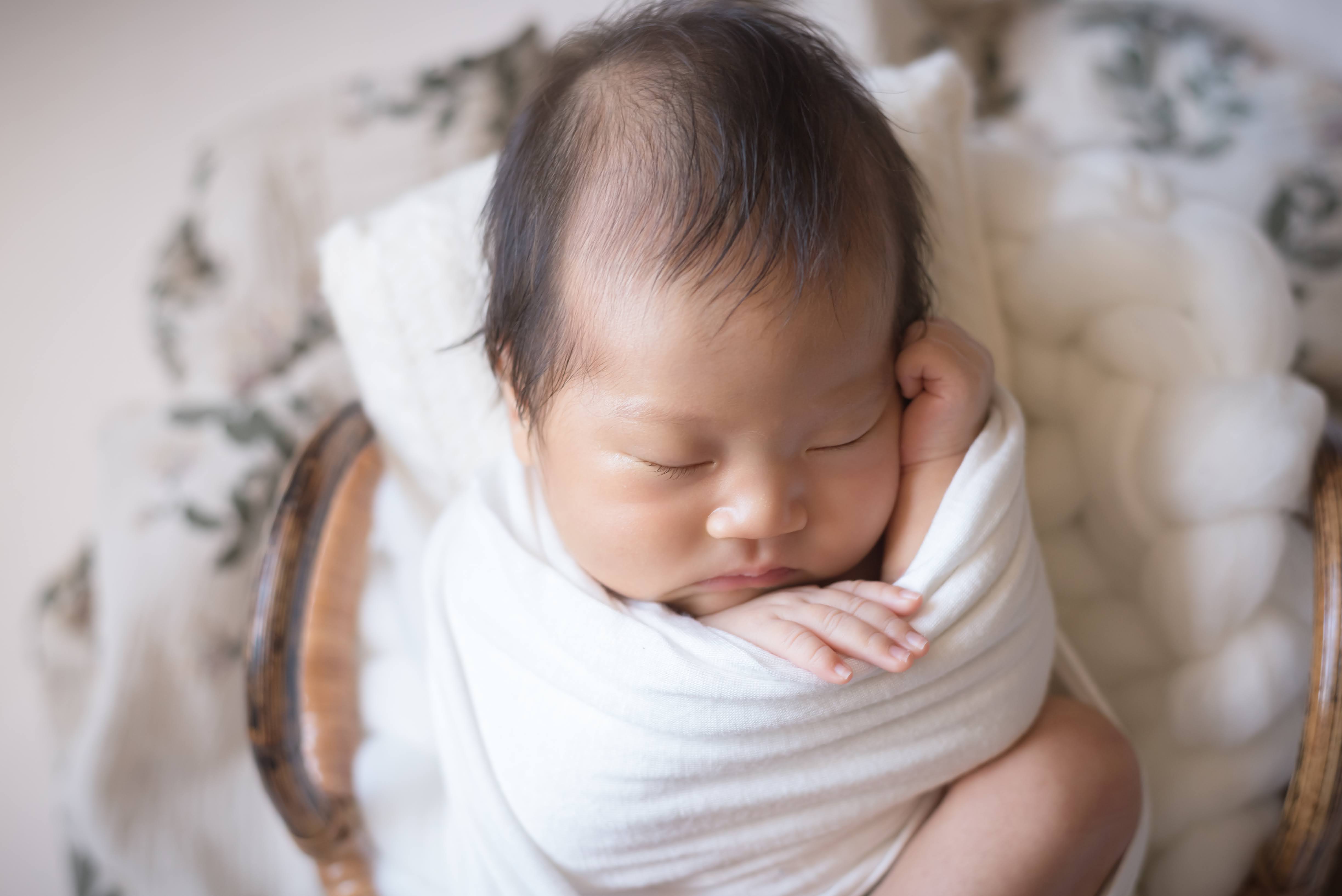 やわらかな毛布に包まれて眠る赤ちゃん